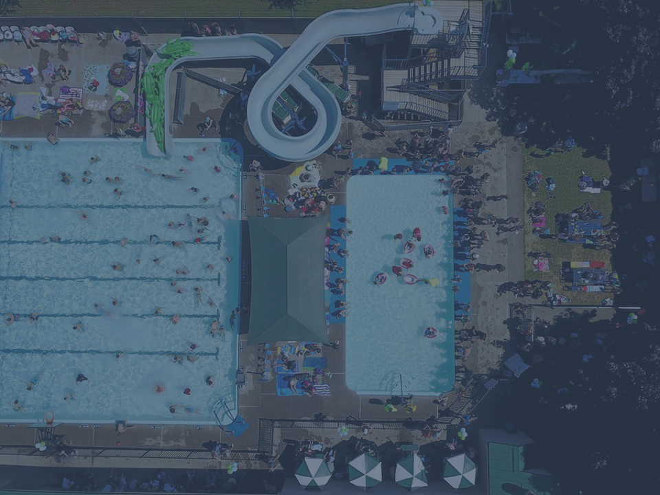Overhead view of crowds of people in and around outdoor pools, during our Splash Day celebration.